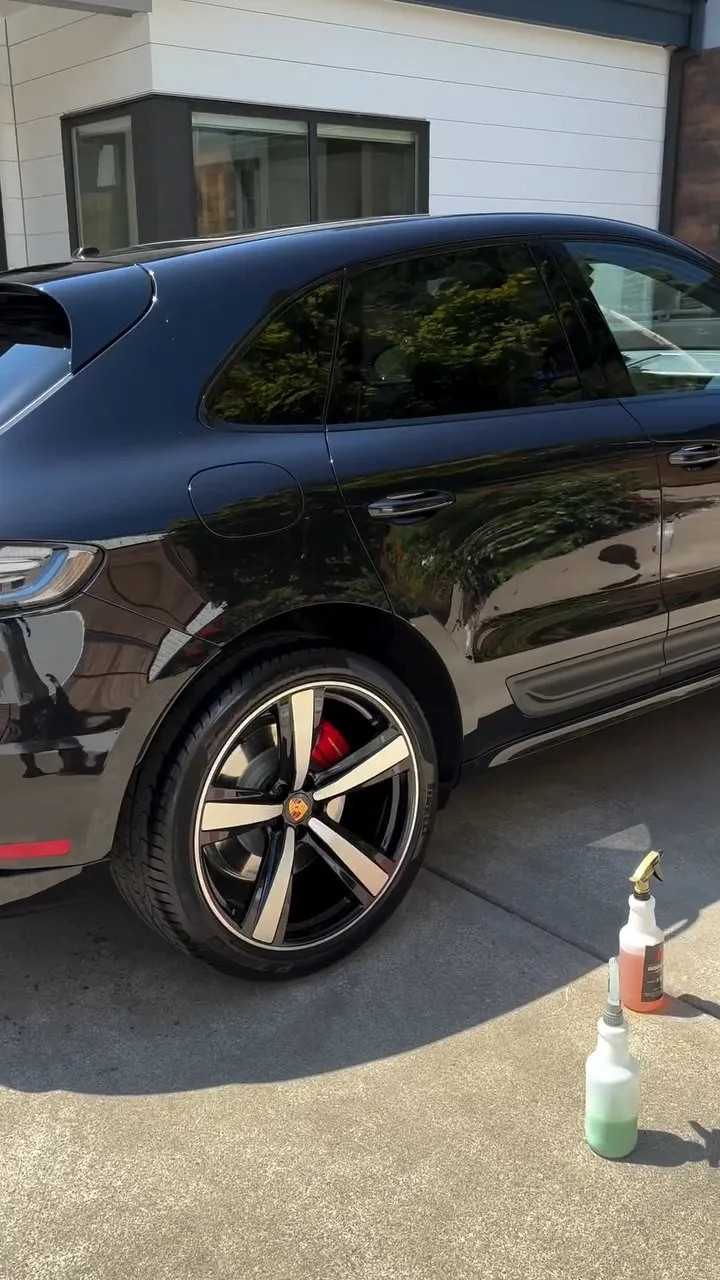 Black Porsche Macan being detailed at a customer driveway